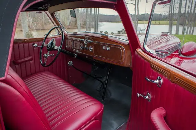 A restored red vintage interior, upholstery and wood dash.