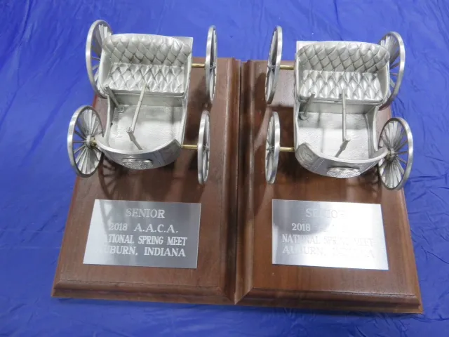 Two wooden award plaques topped with silver carriage figures, each engraved “Senior, 2018 A.A.C.A. National Spring Meet, Auburn, Indiana.”