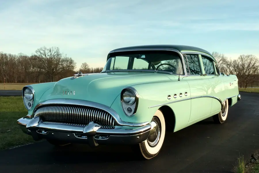 A mint restored 1950s sedan, low front angle in warm light.