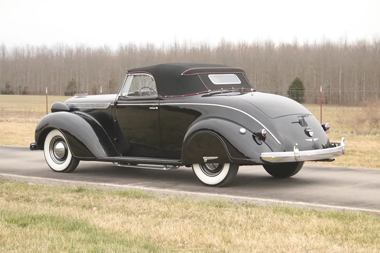 Black Betty finished in black, top up, rear three-quarter on a country road.