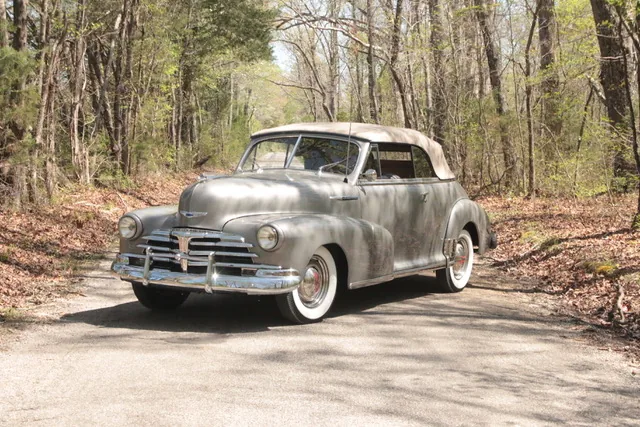 The restored 1948 Chevrolet Fleetmaster convertible in silver-grey with a tan top, front three-quarter.